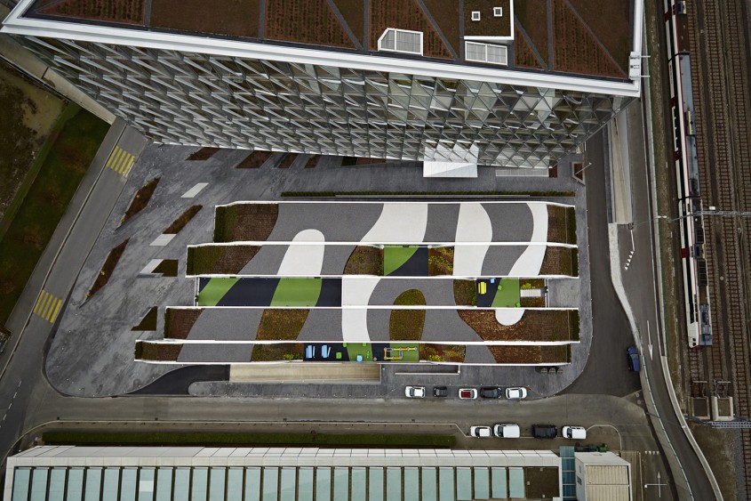 Gradinita Origami - Un acoperis verde intre doua cladiri de birouri mascheaza spatiile unei gradinite