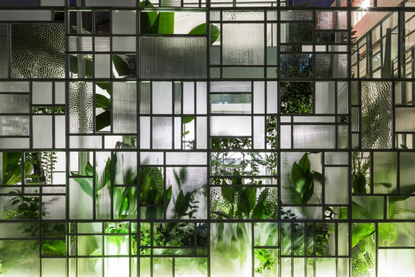 Pereții din sticlă ai unui restaurant din Vietnam acoperiți de plante tropicale - Pereții din sticlă