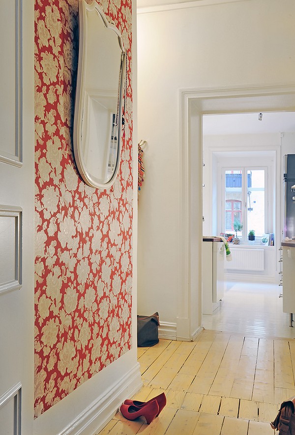 Un alt hol un perete imbracat in tapet cu note vii de rosu - Un apartament