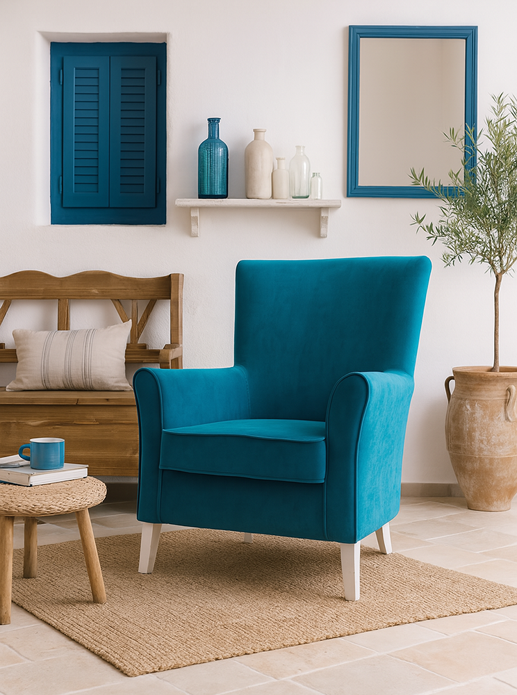 Fotoliu turcoaz într-un living decorat în stil mediteranean cu perete alb accente albastre mobilier din lemn