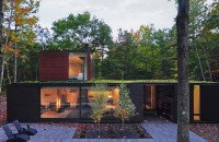 O casa cu acoperisuri verzi se ascunde de minune in padure