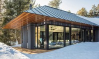 O casă de oaspeți construită pe structură metalică și înconjurată de pădurea din Vermont