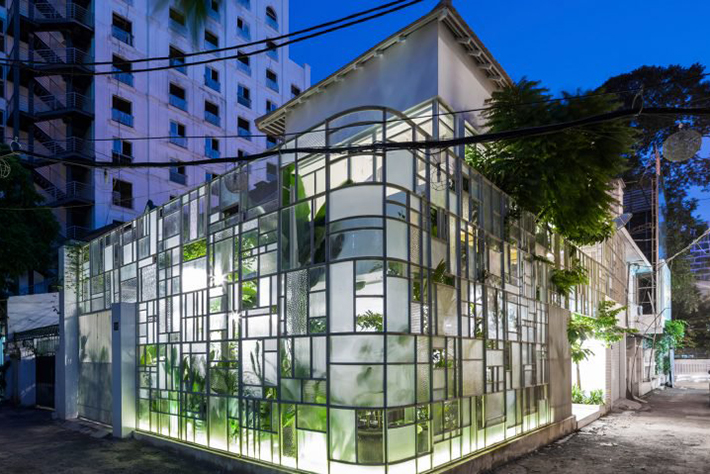 Fațada de sticlă a unui restaurant din Vietnam placată cu plante tropicale