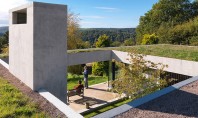 Un acoperis verde asigura continuitatea casei in peisajul inconjurator Luminatoare strapung din loc in loc acest