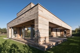 O casă cu o geometrie simplă, îmbrăcată în lemn de cedru