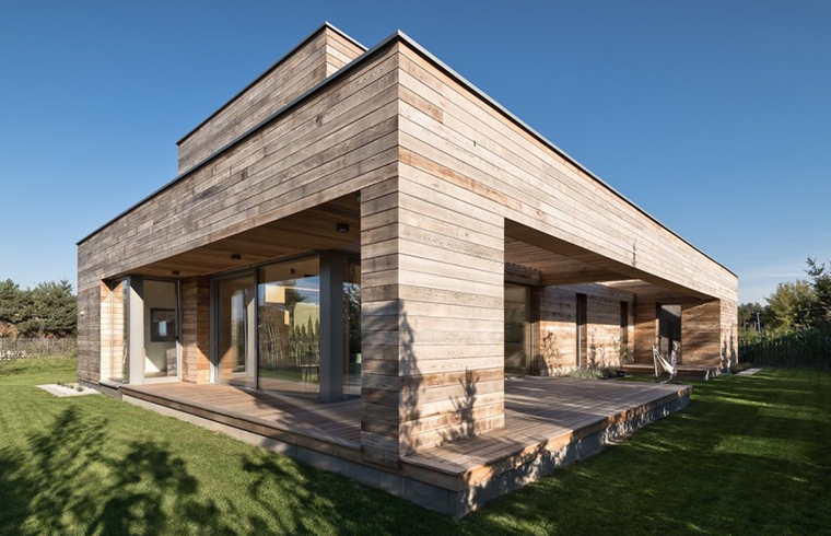 O casă cu o geometrie simplă, îmbrăcată în lemn de cedru