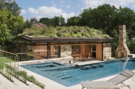 O piscină modernă pune în valoare o cabană din lemn și sticlă cu un acoperiș plin