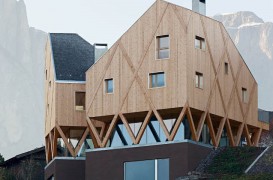 O casă pe structură din lemn a cărei volumetrie imită relieful muntos din împrejurimi