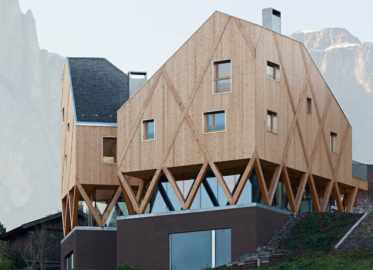 O casă pe structură din lemn a cărei volumetrie imită relieful muntos din împrejurimi