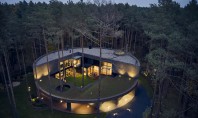 O casă circulară construită printre arbori într-o pădure de pini Construcţia a fost proiectată de biroul